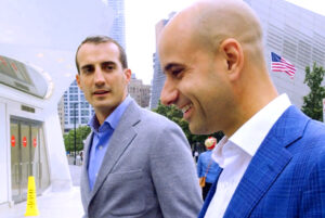 Two men walking around in the financial districts in New York City.
