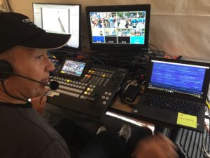 A man in a video booth running equipment