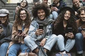 Group gathers on phone, watching social media ads
