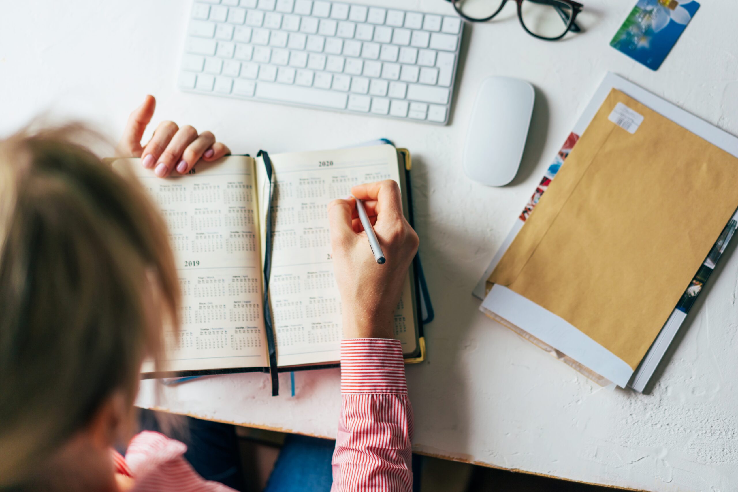 Woman uses schedule and calendar to plan production, post-production marketing strategy