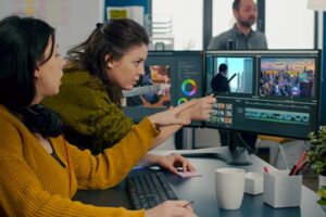 Multiple female employees collaborate in editing bay on financial video