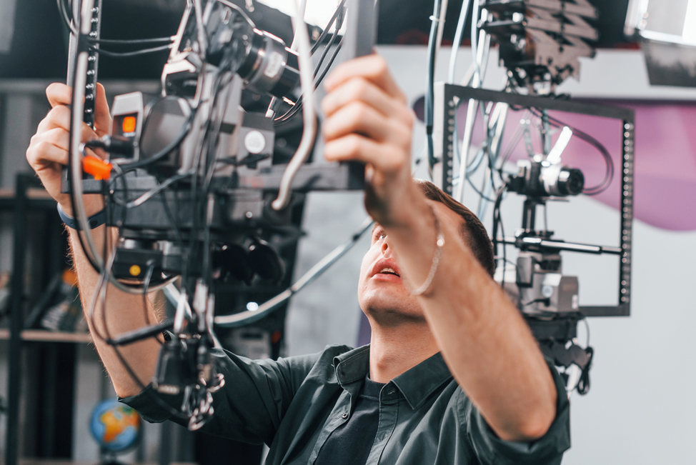 A student adjusting a lighting rig during a very high profile video shoot featuring Madonna and Justin Timberlake
