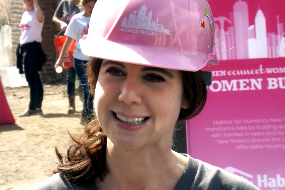 A female worker helping to build a home in a video for Habitat for Humanity