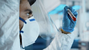 Scientist shaking a vile containing a contageous disease