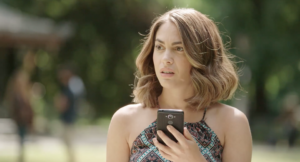 Woman in Park looking confused while holding her cell phone