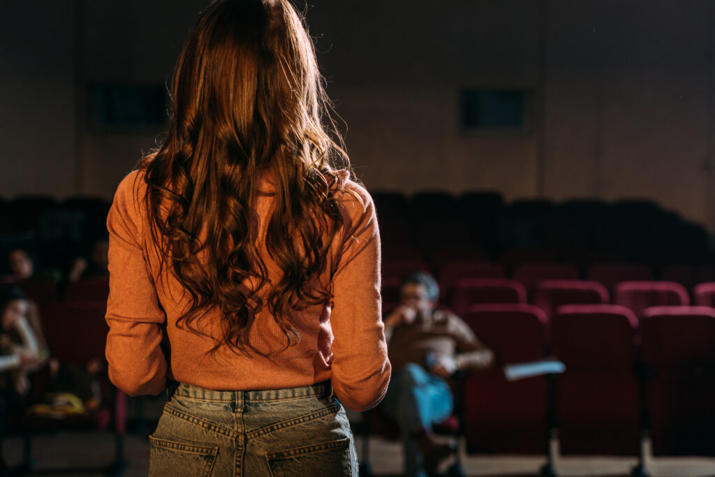 Woman on a stage giving an acting audition for the Indigo Productions creative team