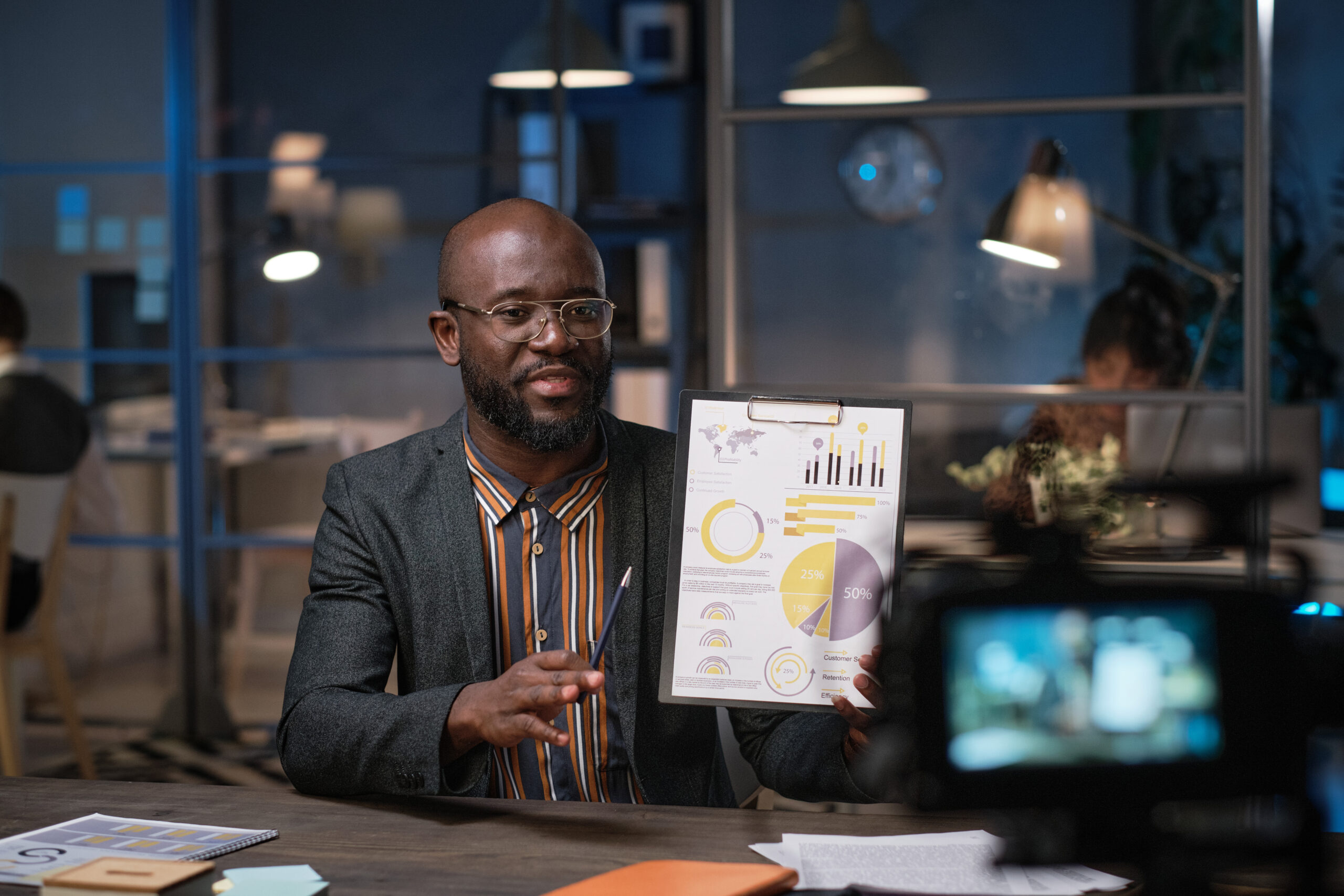 African American Man showing off some random charts and graphs in a stock photo