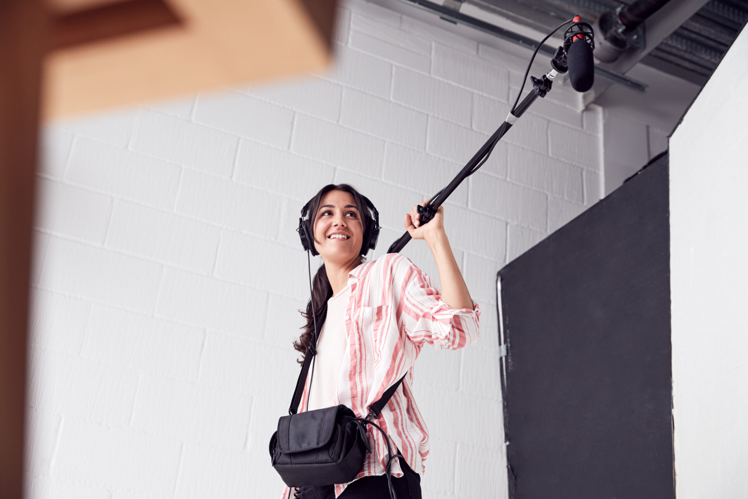 Woman operates boom and mixer for professional film shoot