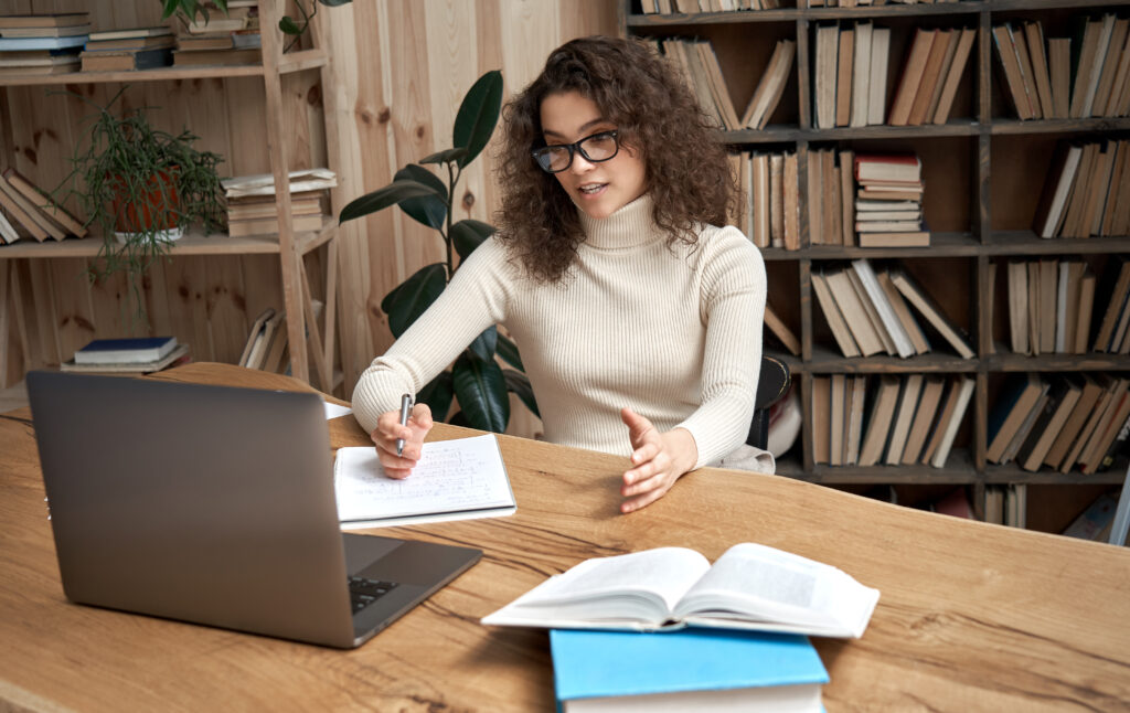 Beautiful woman in white turtleneck sweater yelling and gesturing at her laptop computer