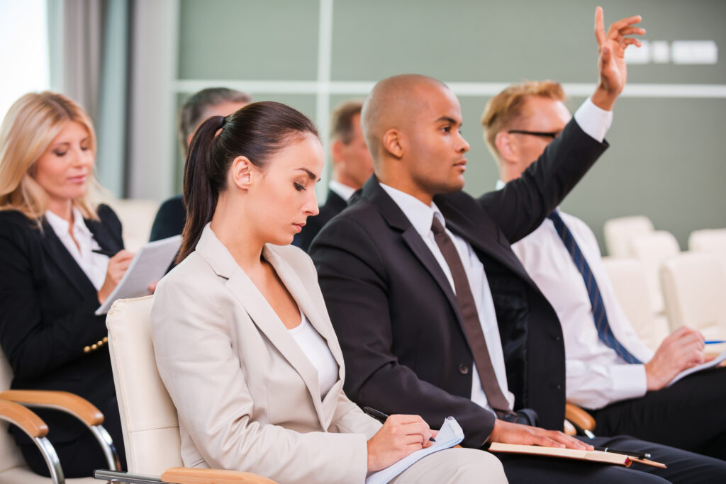 Multi-racial audience members at a small corporate event